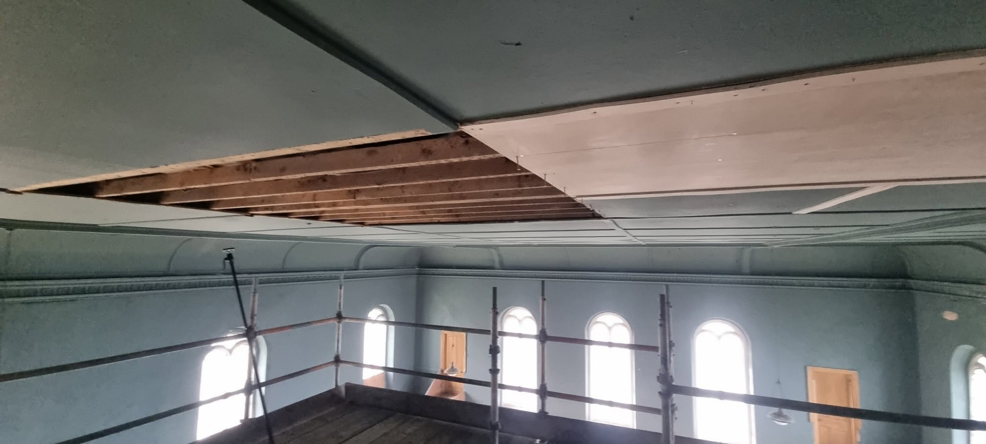 Ceiling at St Ouen's Methodist Church with a section of boards removed, exposing the original timber joists
